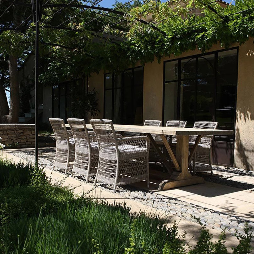 Hampton Outdoor Dining Chairs in Stone around a rectangle wooden table on a patio